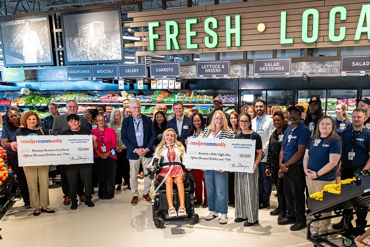 Representatives from Breaking Barriers Food Pantry and Anastasia & Katie's Coffee Shop holding $15,000 donation checks at the new Livonia Meijer grand opening.